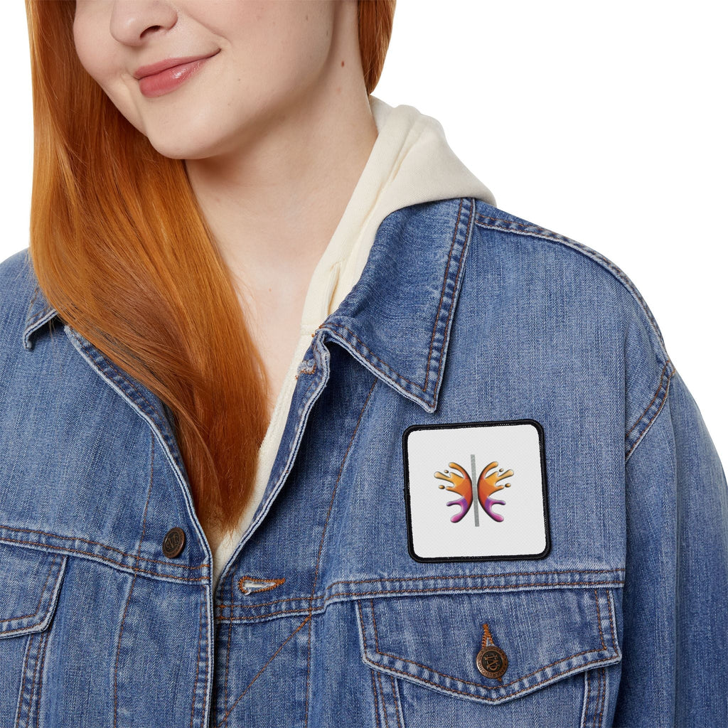 Person wearing denim jacket with square Iron Patch featuring colorful design.
