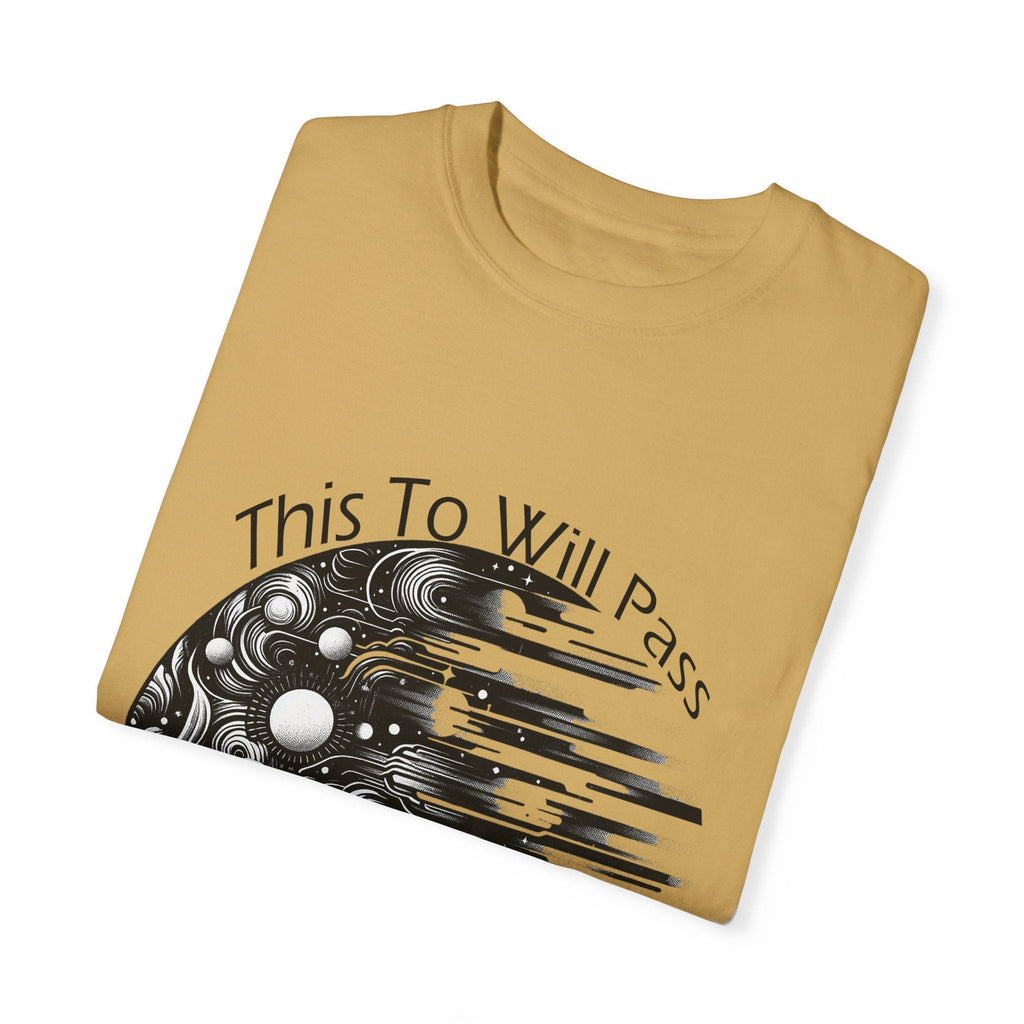Unisex garment-dyed T-shirt with "This Too Will Pass" inspirational design, folded and displayed.