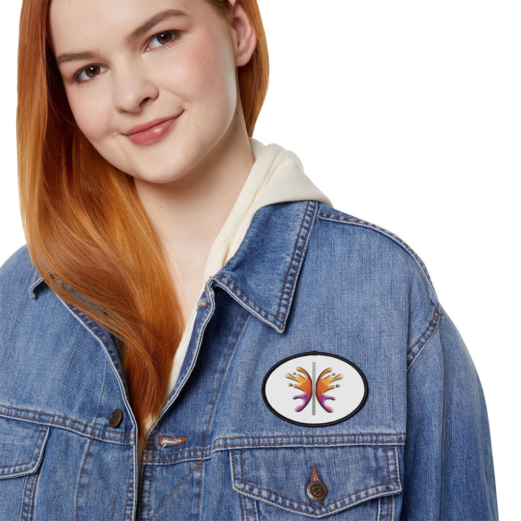 Person wearing a denim jacket with an oval iron patch for personalizing apparel.